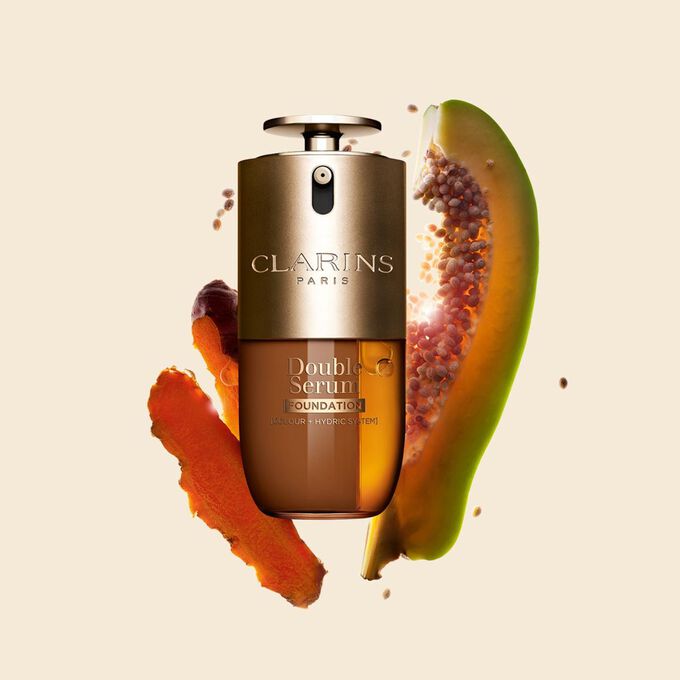 Packshot di Double Serum Foundation Clarins, disponibile per ogni tipo di carnagione, con ingredienti chiave come curcuma e papaia.