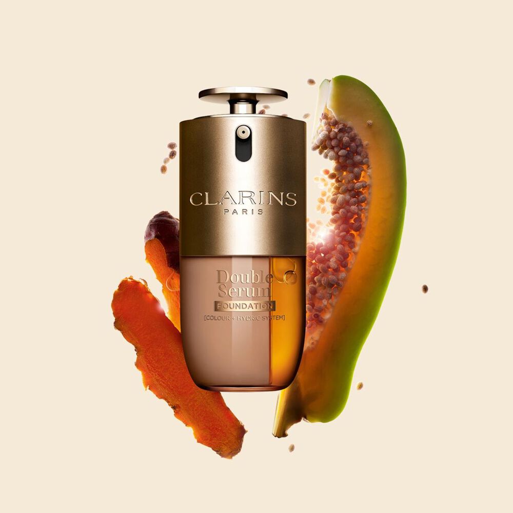 Packshot di Double Serum Foundation Clarins, disponibile per ogni tipo di carnagione, con ingredienti chiave come curcuma e papaia.