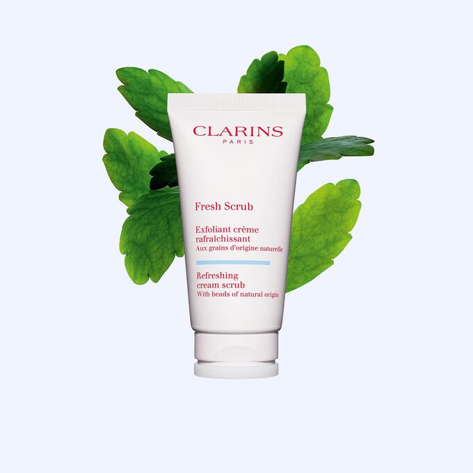 Packshot tubo di esfoliante viso Fresh Scrub accanto a pianta di Goethe su sfondo bianco.