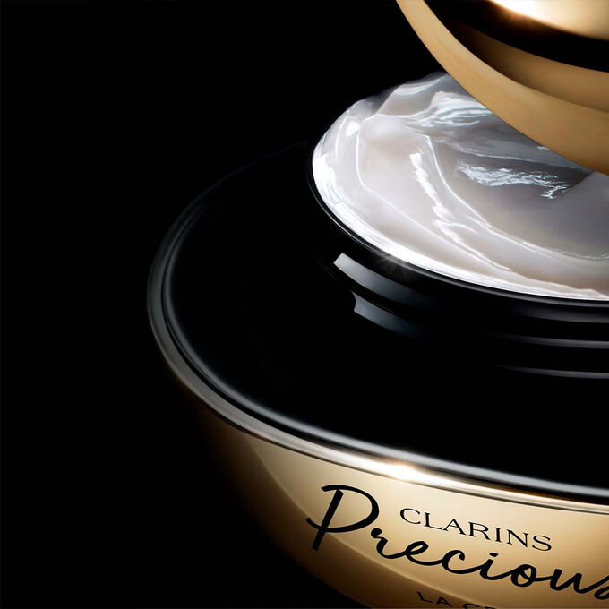 Primo piano della crema di alta gamma Clarins Precious, che mostra una texture idratante bianca ricca, morbida e cremosa.