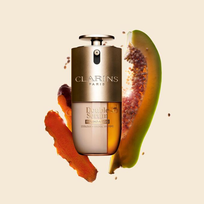 Packshot di Double Serum Foundation Clarins, disponibile per ogni tipo di carnagione, con ingredienti chiave come curcuma e papaia.