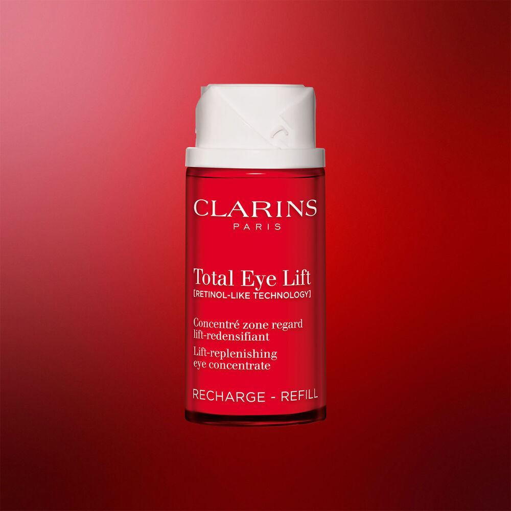 Packshot della confezione della ricarica della crema contorno occhi anti-et&agrave; Clarins Total Eye Lift su sfondo rosso scuro, che evidenzia il suo design sostenibile e ricaricabile.