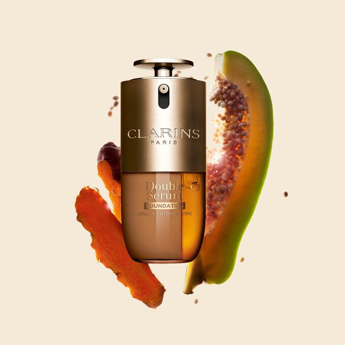 Packshot di Double Serum Foundation Clarins, disponibile per ogni tipo di carnagione, con ingredienti chiave come curcuma e papaia.