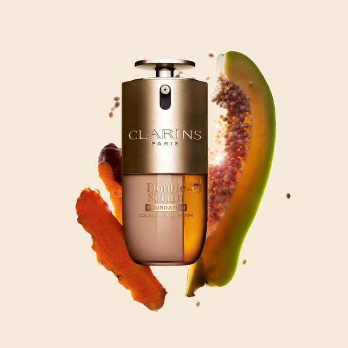 Packshot di Double Serum Foundation Clarins, disponibile per ogni tipo di carnagione, con ingredienti chiave come curcuma e papaia.