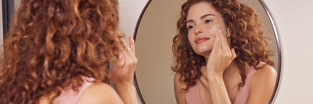 Donna che si spalma la crema sul viso