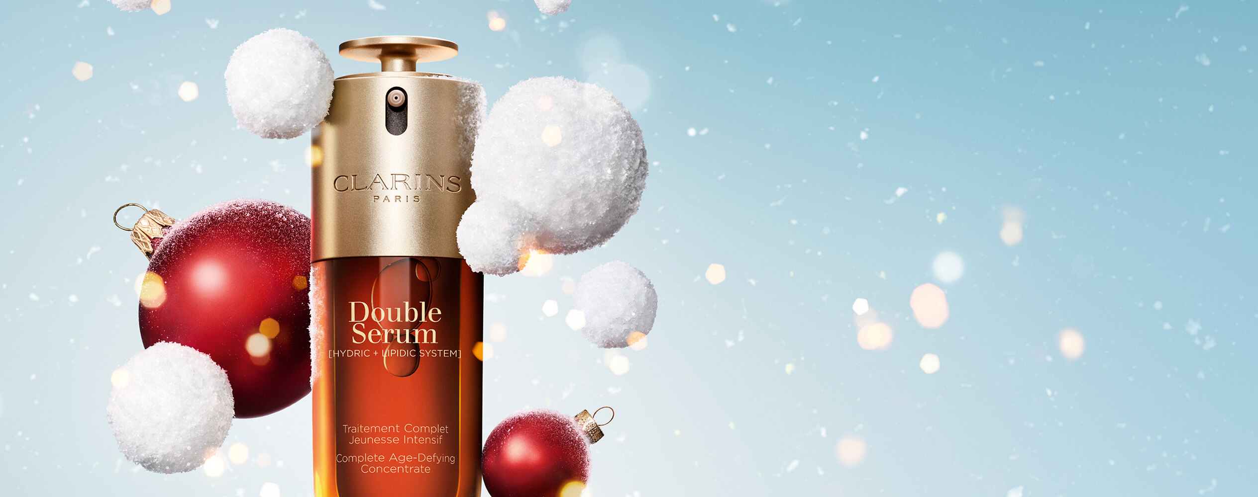 Double Serum su uno sfondo natalizio innevato con palle di neve e palline di Natale rosse