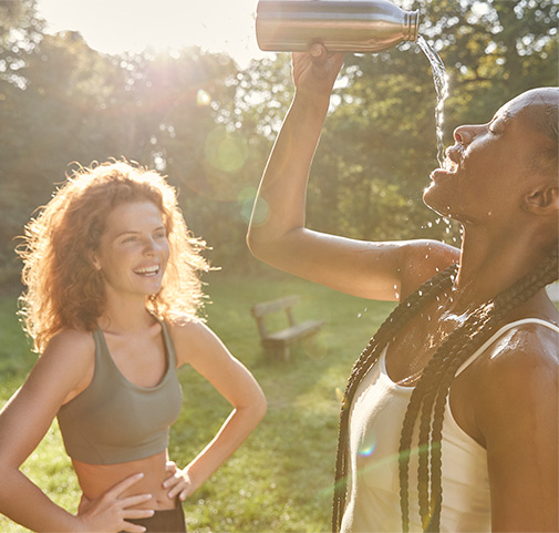 Due giovani donne che bevono acqua e ridono